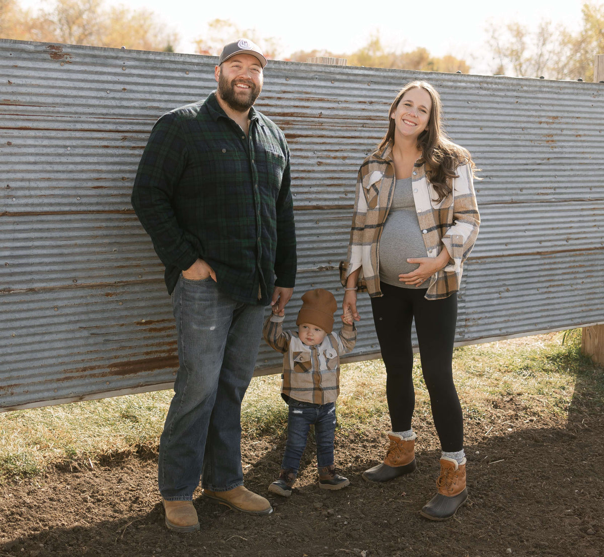 ryan peterson and family standing in front of metal paneling smiling