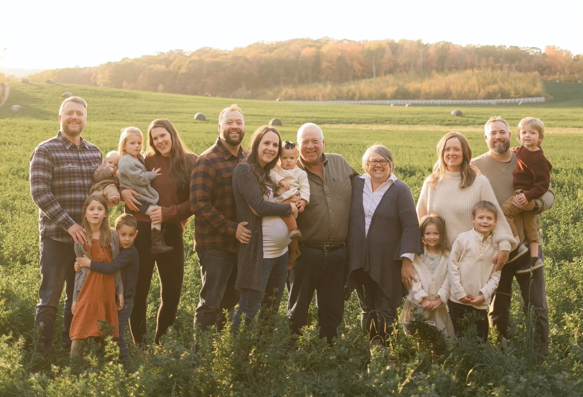 peterson family smiling and standing in a hay field